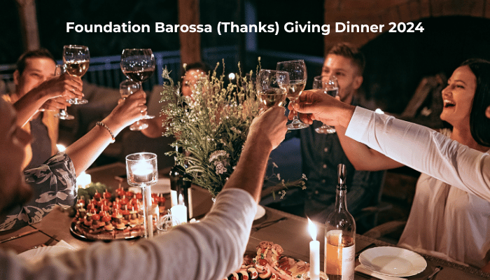 People around a table raising their glasses. The text says Foundation Barossa (Thanks) Giving Dinner